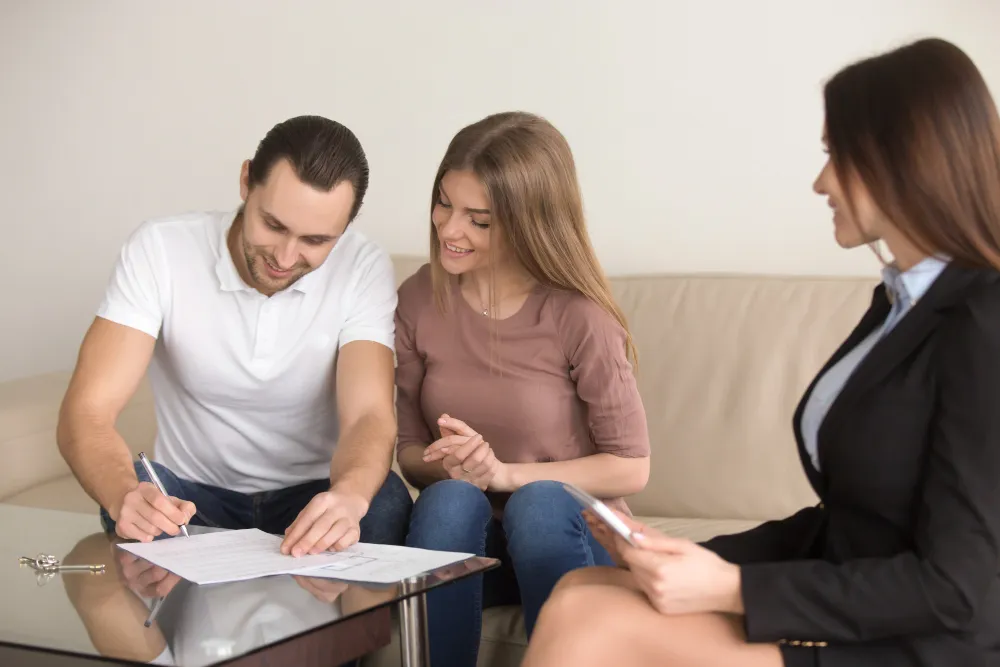Couple signing personal loan agreement with female broker in Ipswich Augustine Heights QLD